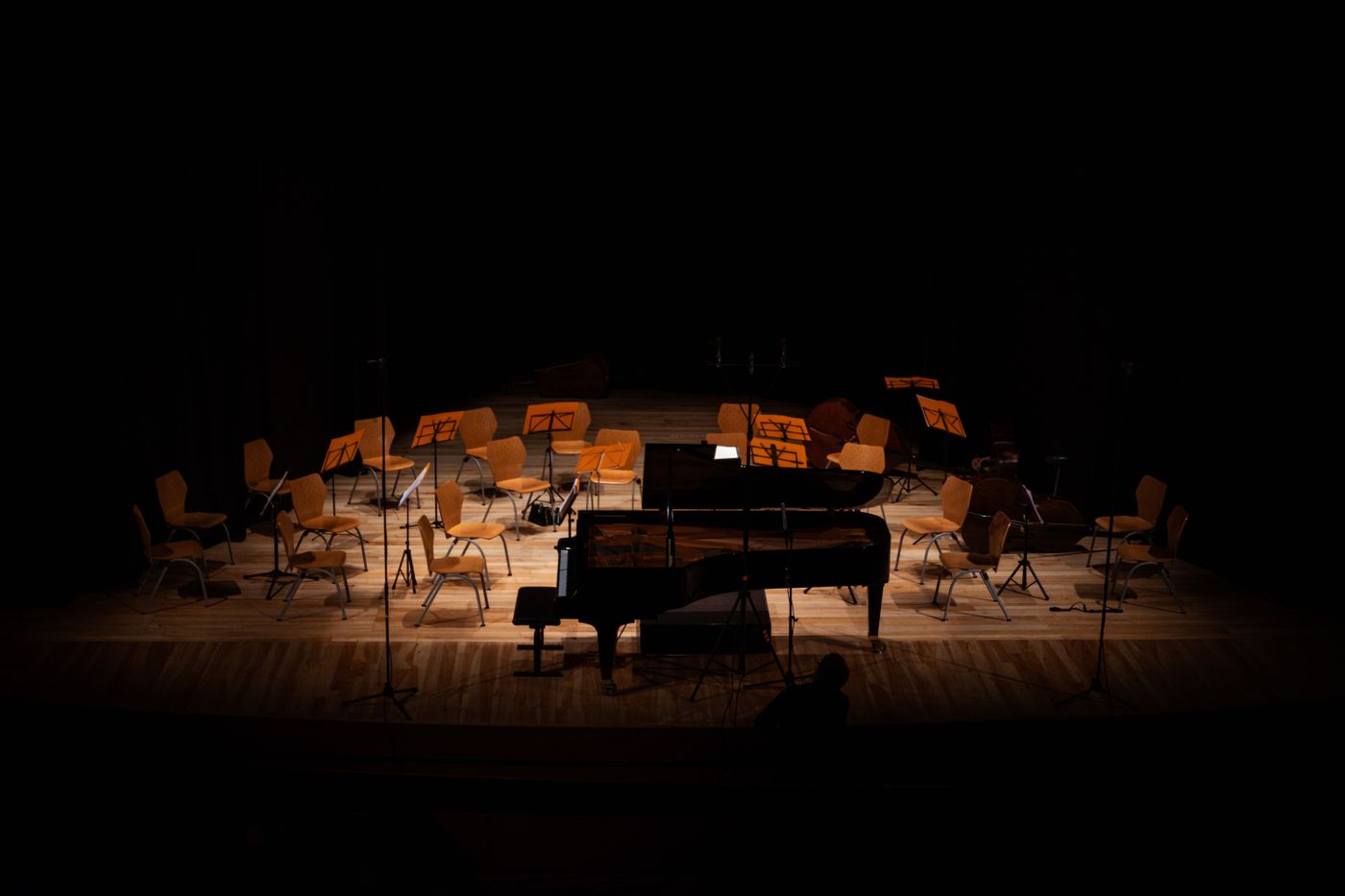 Leeg concertpodium met vleugel en stoelen in warm licht