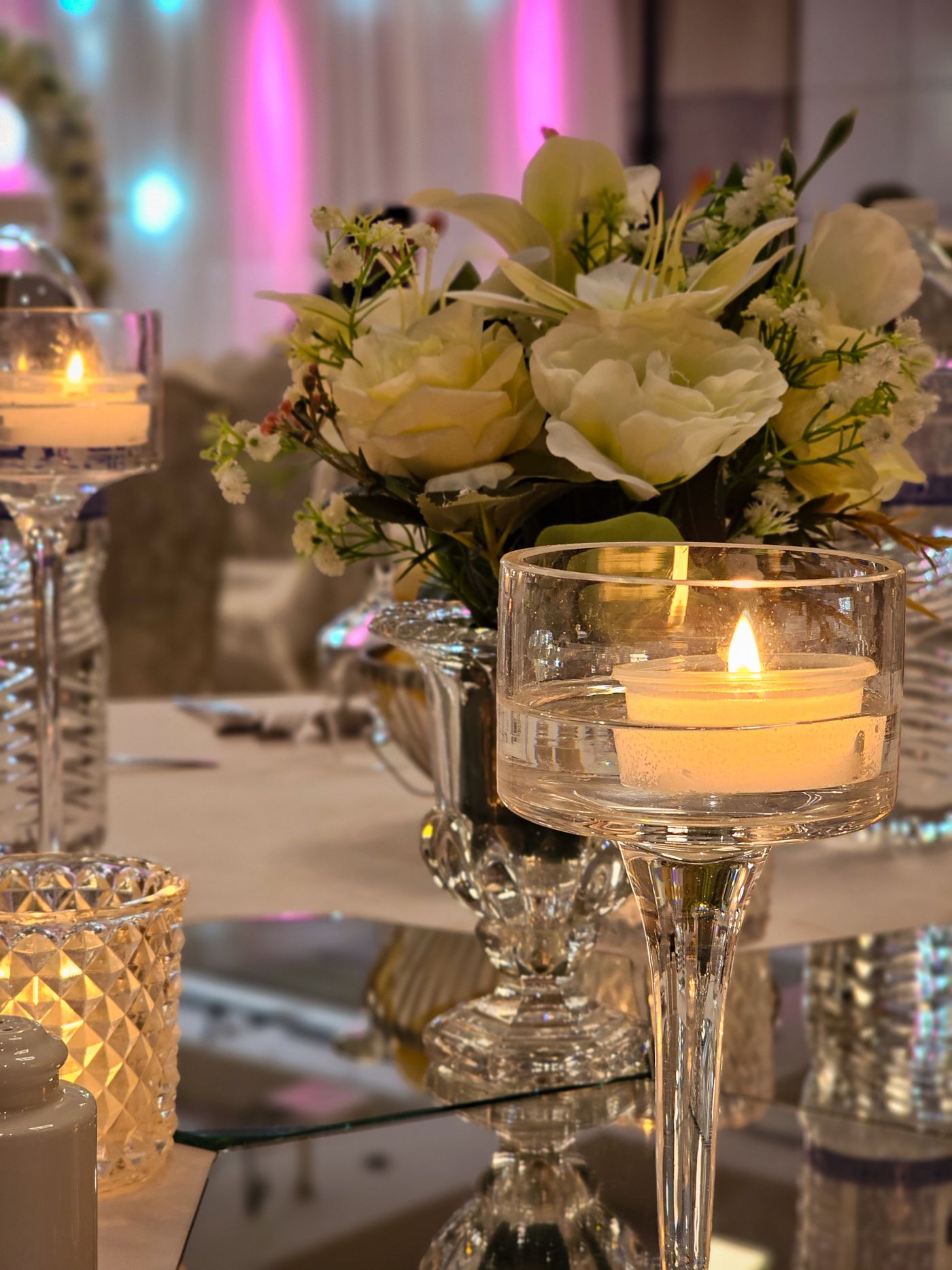 Feestelijk gedekte tafel met witte bloemen en brandende kaarsen